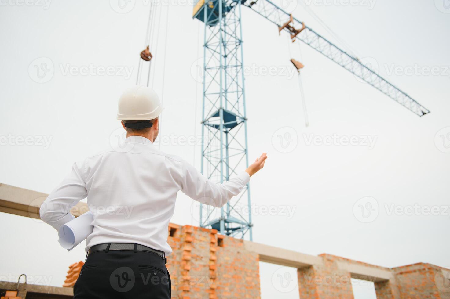 Architect at a construction site with blueprints photo