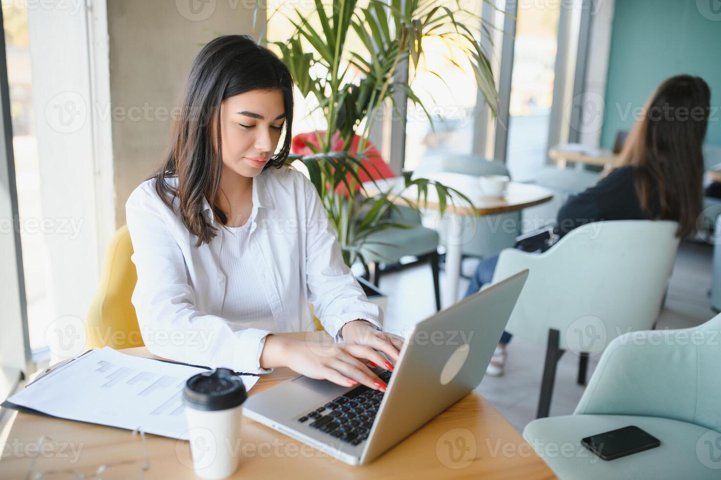 Smiling girl student study online with skype teacher, happy young woman learn language listen lecture watch webinar write notes look at laptop sit in cafe, distant education photo
