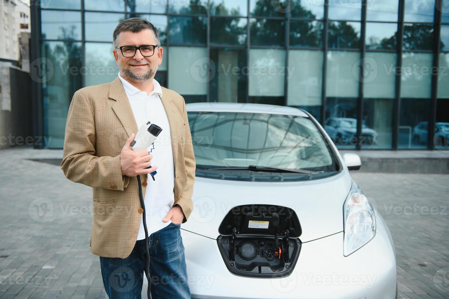 Man holding power connector for electric car photo