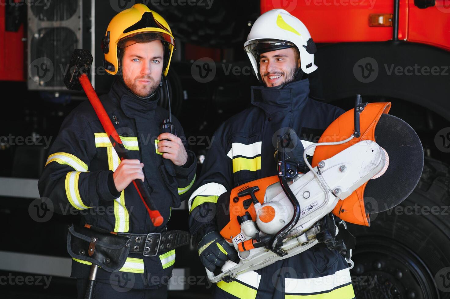 Portrait of two heroic fireman in protective suit and helmet. photo