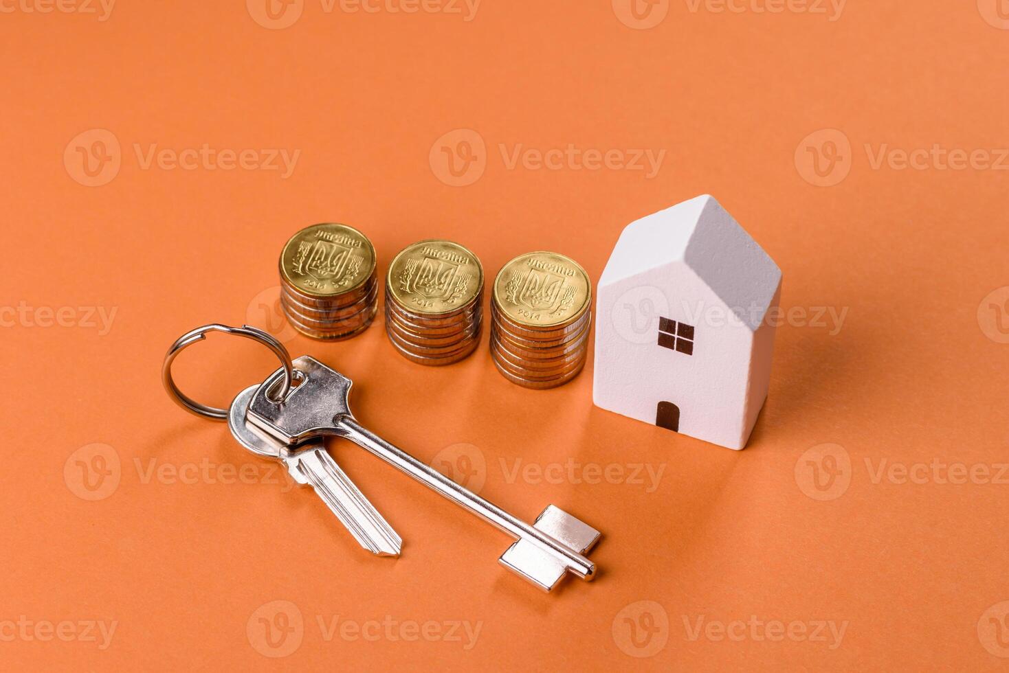 A small wooden house, money and keys as an idea for investing in your own home photo