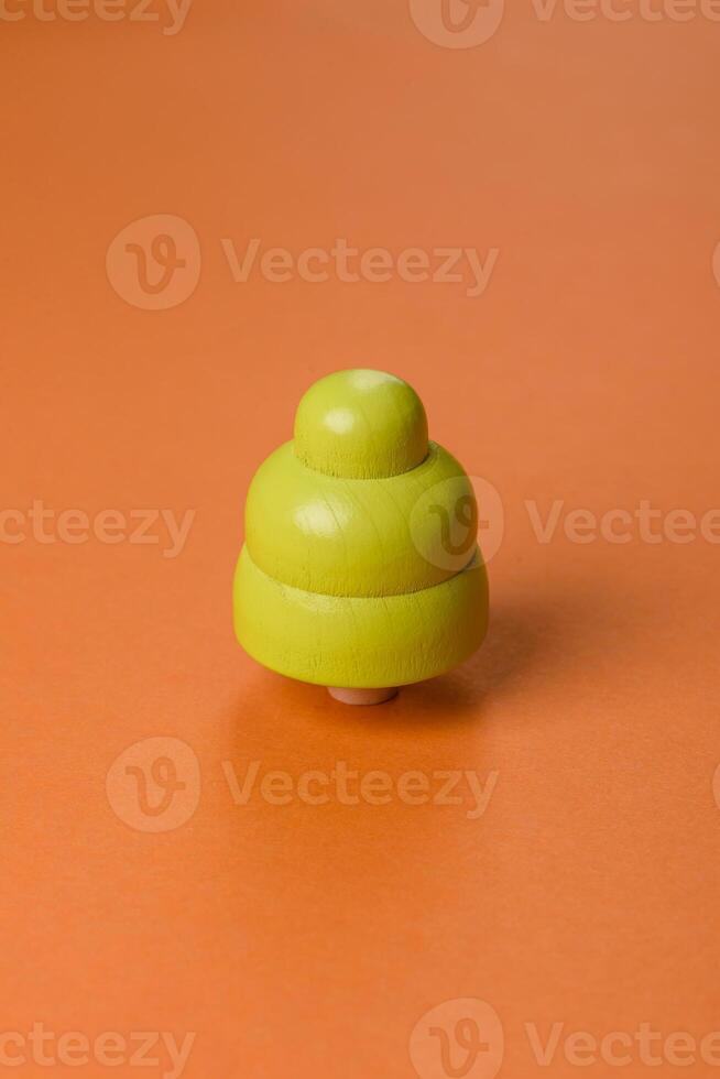 Wooden model of a tree with a green crown and trunk on a orange background photo