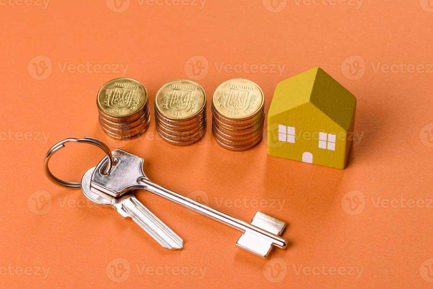 A small wooden house, money and keys as an idea for investing in your own home photo