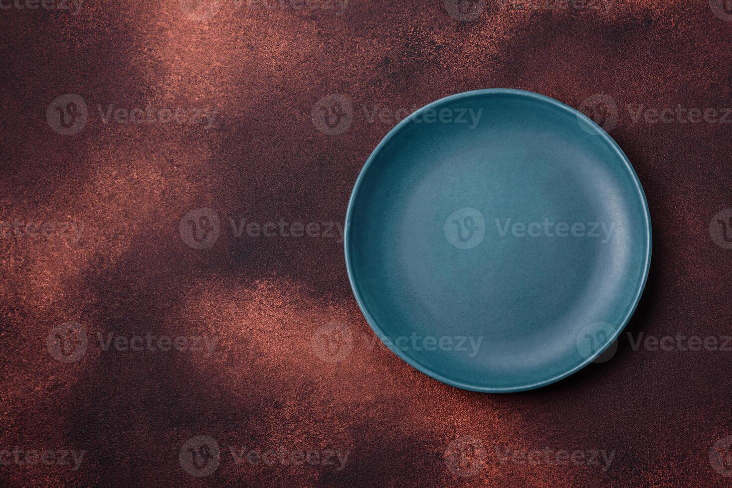 Empty ceramic round plate on dark textured concrete background photo