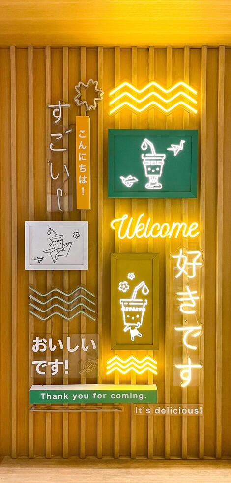 Jakarta, Indonesia - February 19th, 2024 - Cute wall poster and light decoration in ShuShu beverage drink cafe interior Grand Indonesia Mall isolated on wooden vertical ratio background. photo