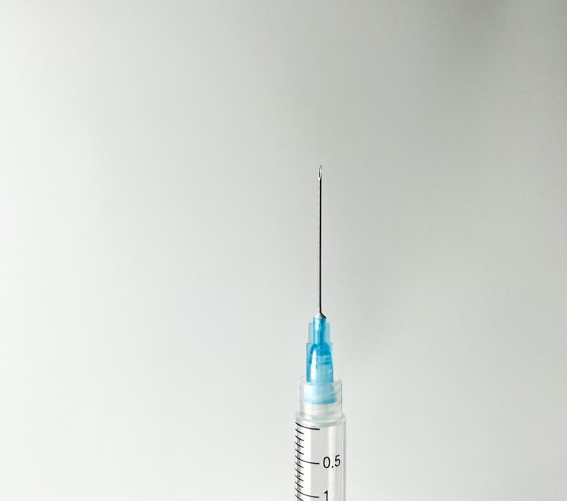 Syringe for injection. Sharp and pointy close up needle tip photography isolated on horizontal copy spaced plain white studio background with no text and nobody. photo