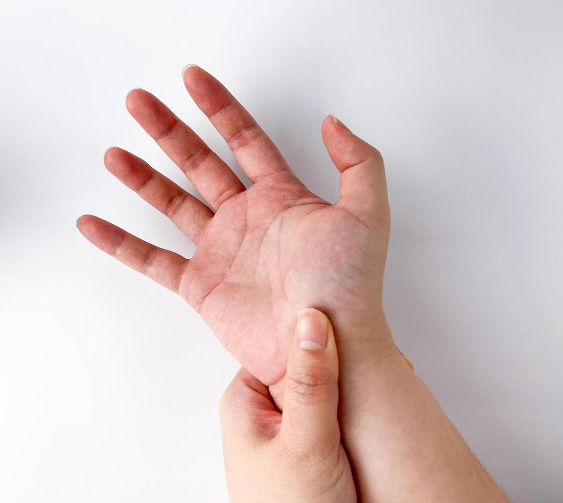 ligero piel tonificado humano mano con masajear mano muñeca actitud gesto. de mano túnel síndrome temática fotografía aislado en blanco estudio antecedentes. foto