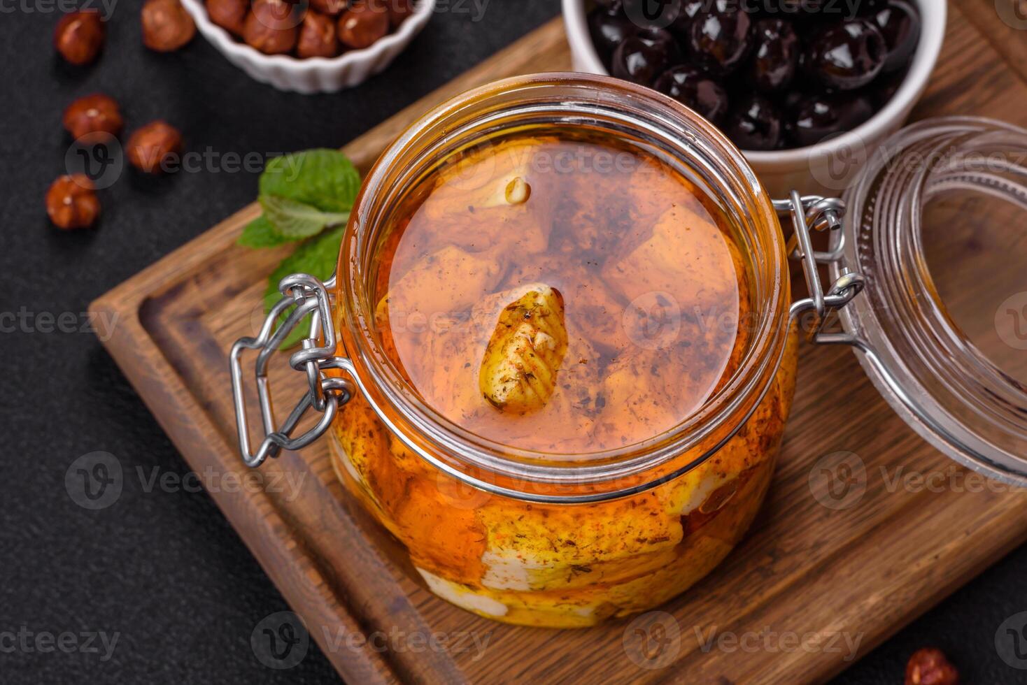 Delicious soft white feta cheese with salt, spices and herbs on a dark concrete background photo