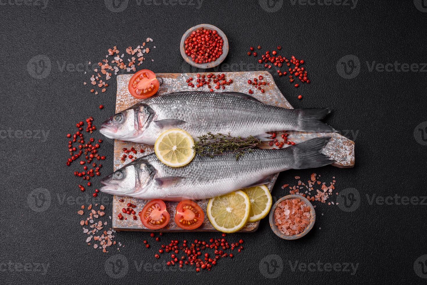 Fresh raw ocean sea bass fish with salt, spices and herbs photo