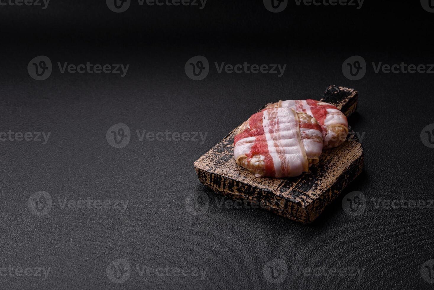 Round minced chicken or pork cutlet wrapped in bacon with salt, spices and herbs photo