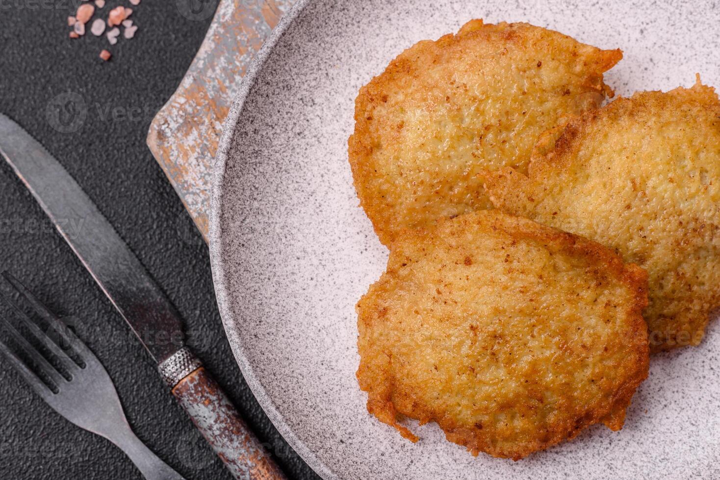 Delicious crispy pancakes made from potatoes, meat, carrots, onions photo