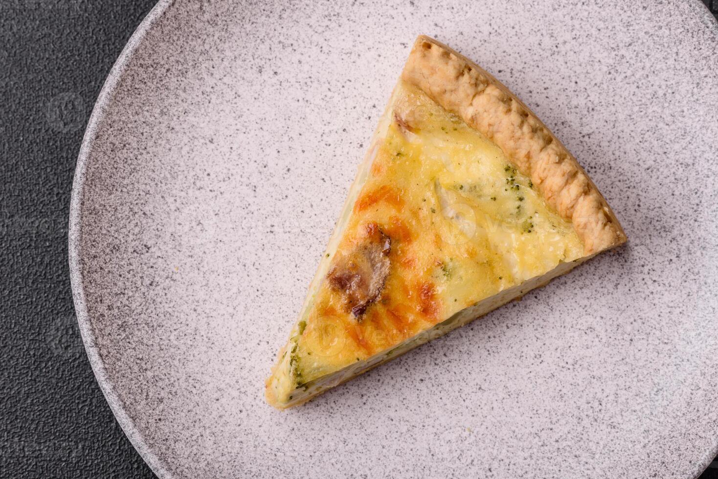 Delicious crispy quiche cut into slices with cheese, broccoli, tomatoes photo