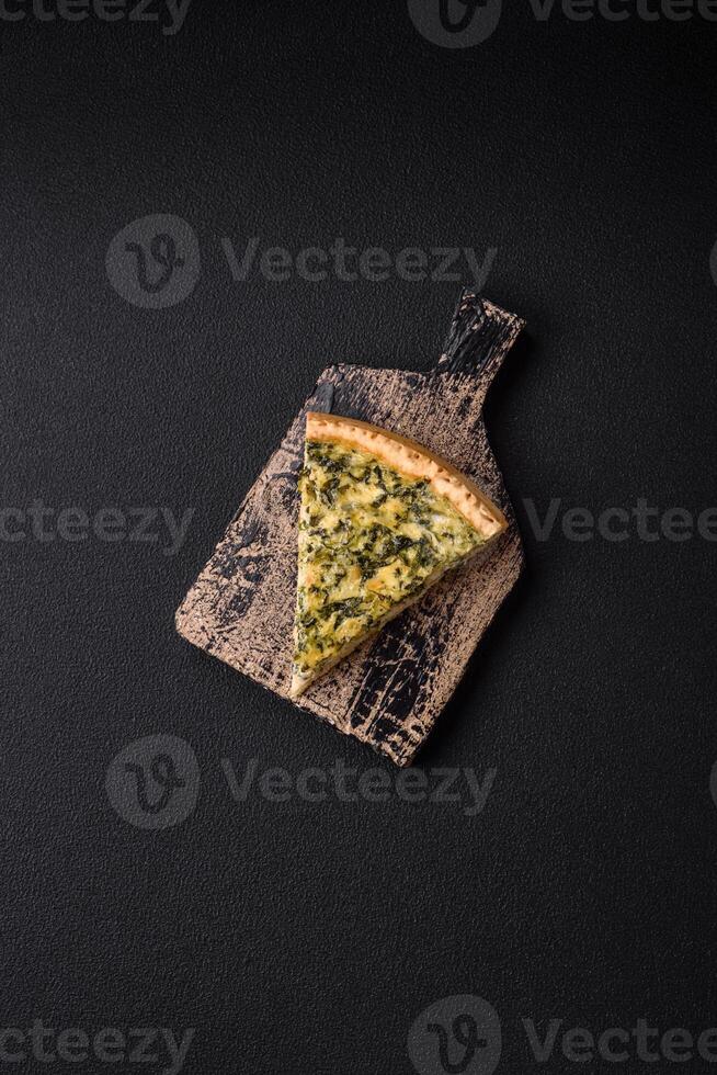 Delicious crispy quiche cut into slices with cheese, broccoli, tomatoes photo