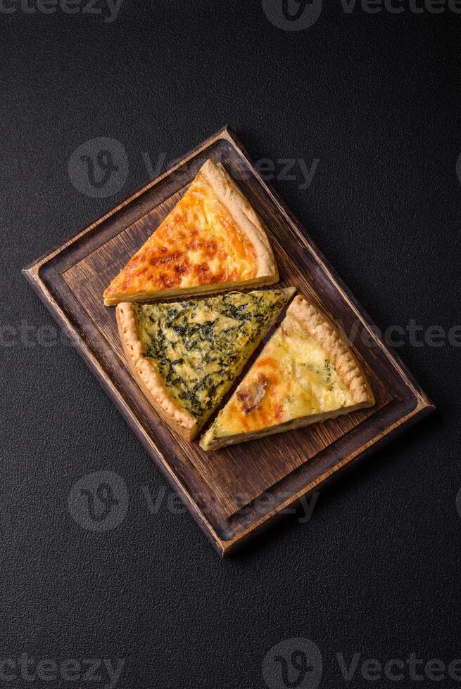 Delicious crispy quiche cut into slices with cheese, broccoli, tomatoes photo