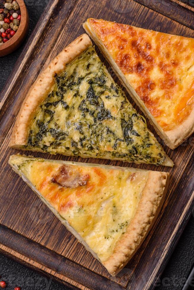 Delicious crispy quiche cut into slices with cheese, broccoli, tomatoes photo