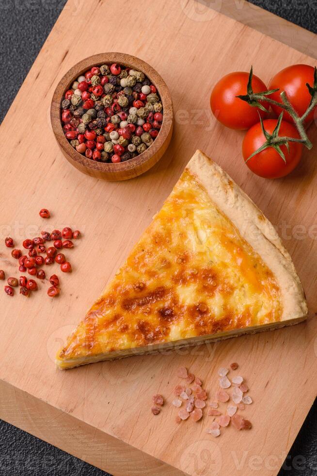 Delicious crispy quiche cut into slices with cheese, broccoli, tomatoes photo