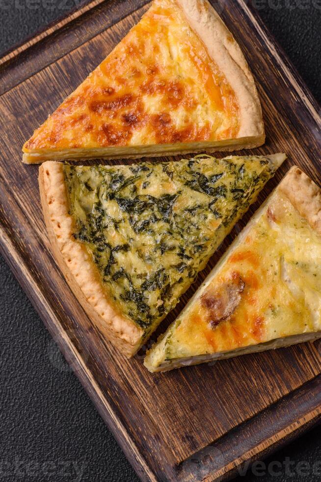 Delicious crispy quiche cut into slices with cheese, broccoli, tomatoes photo
