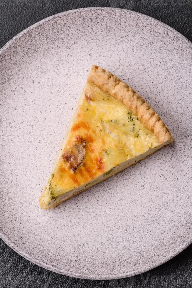 Delicious crispy quiche cut into slices with cheese, broccoli, tomatoes photo