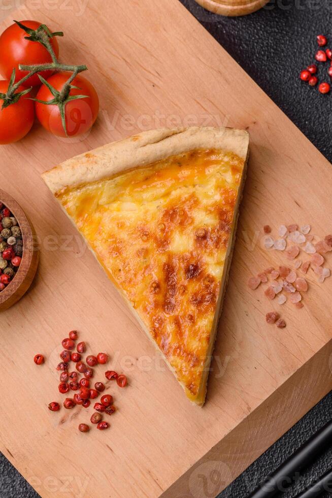 Delicious crispy quiche cut into slices with cheese, broccoli, tomatoes photo