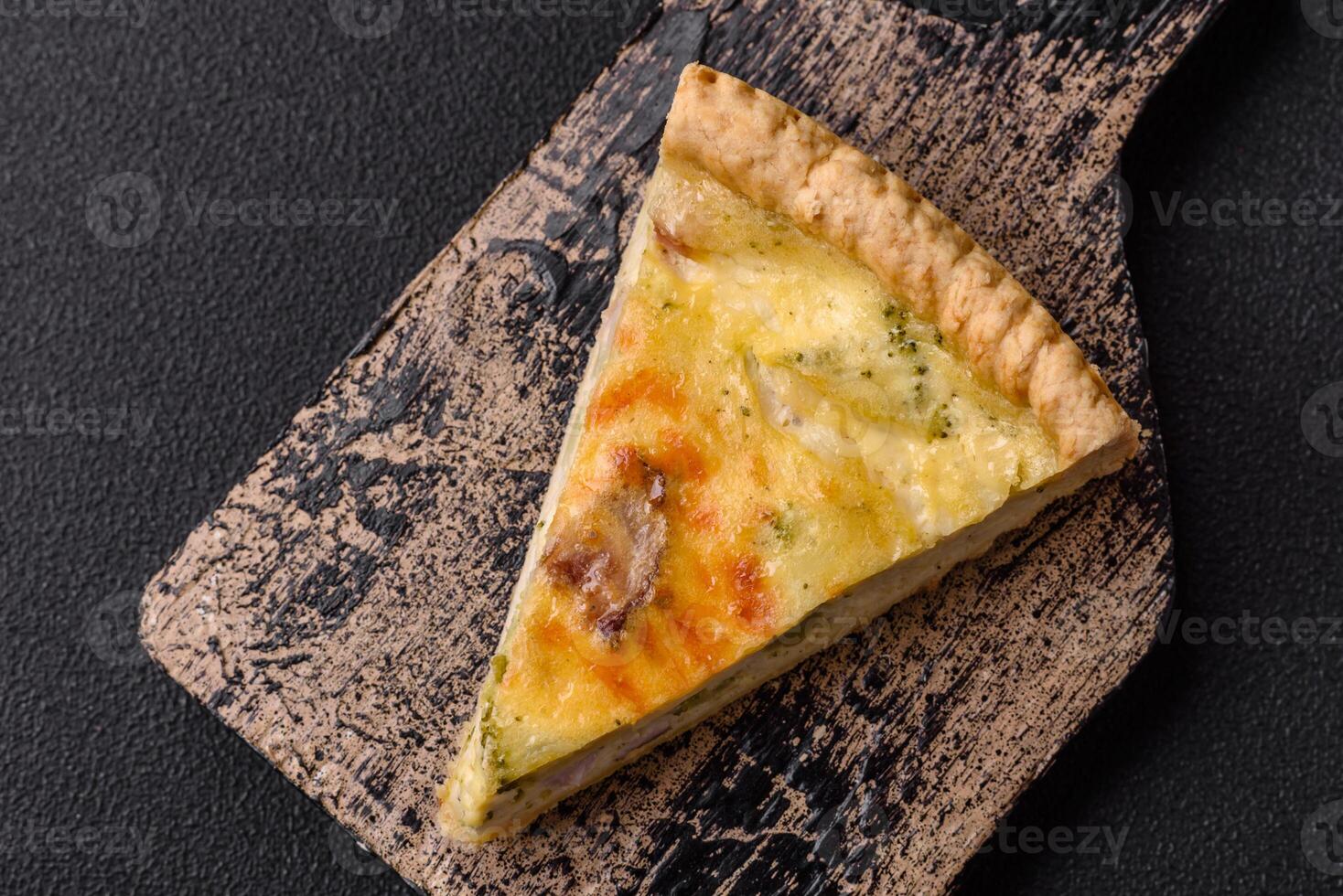 Delicious crispy quiche cut into slices with cheese, broccoli, tomatoes photo