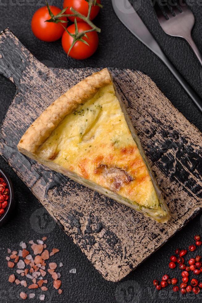 Delicious crispy quiche cut into slices with cheese, broccoli, tomatoes photo