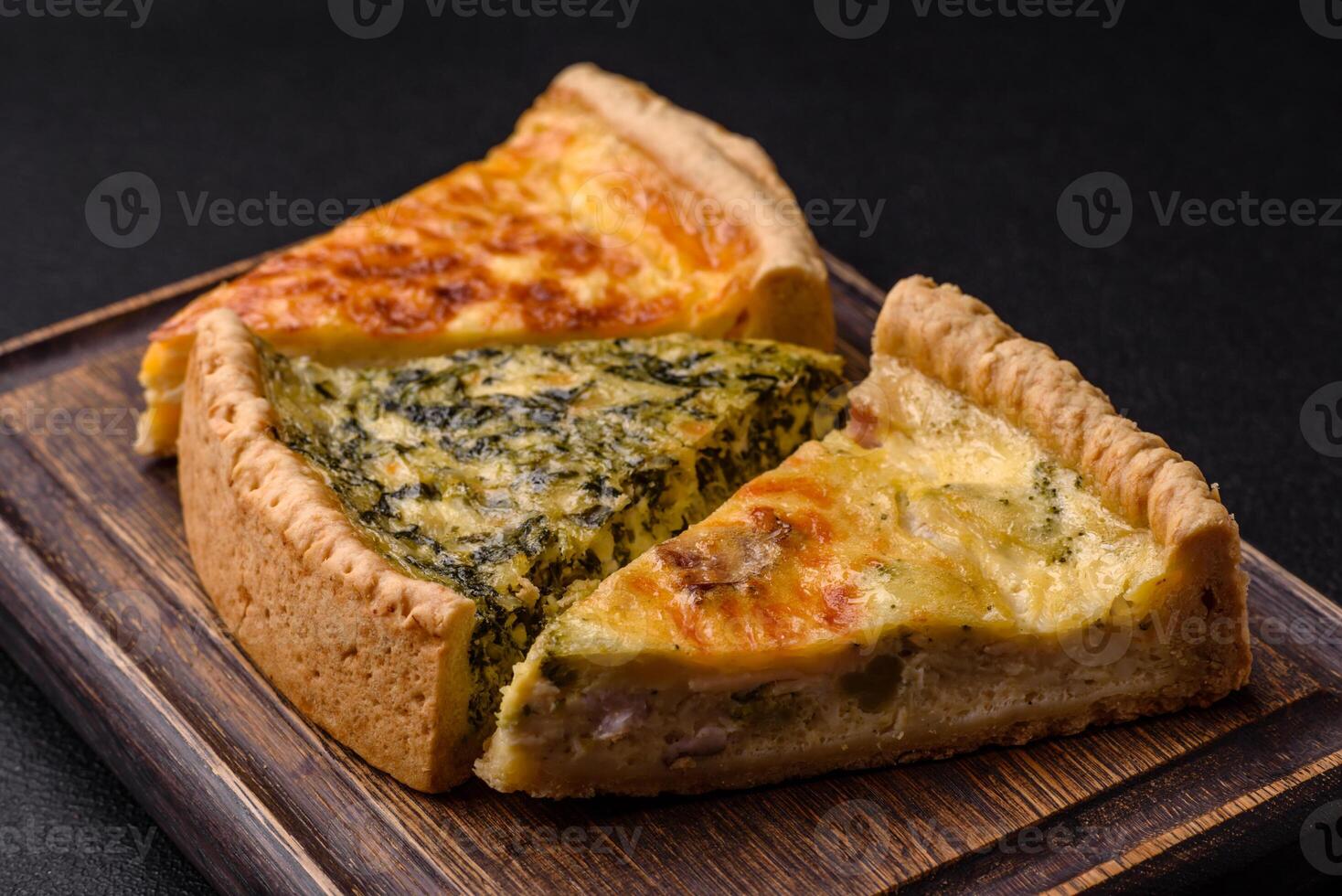 Delicious crispy quiche cut into slices with cheese, broccoli, tomatoes photo