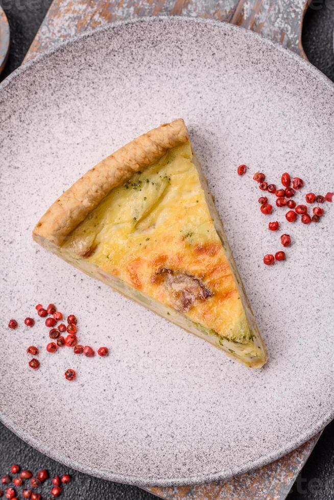 Delicious crispy quiche cut into slices with cheese, broccoli, tomatoes photo