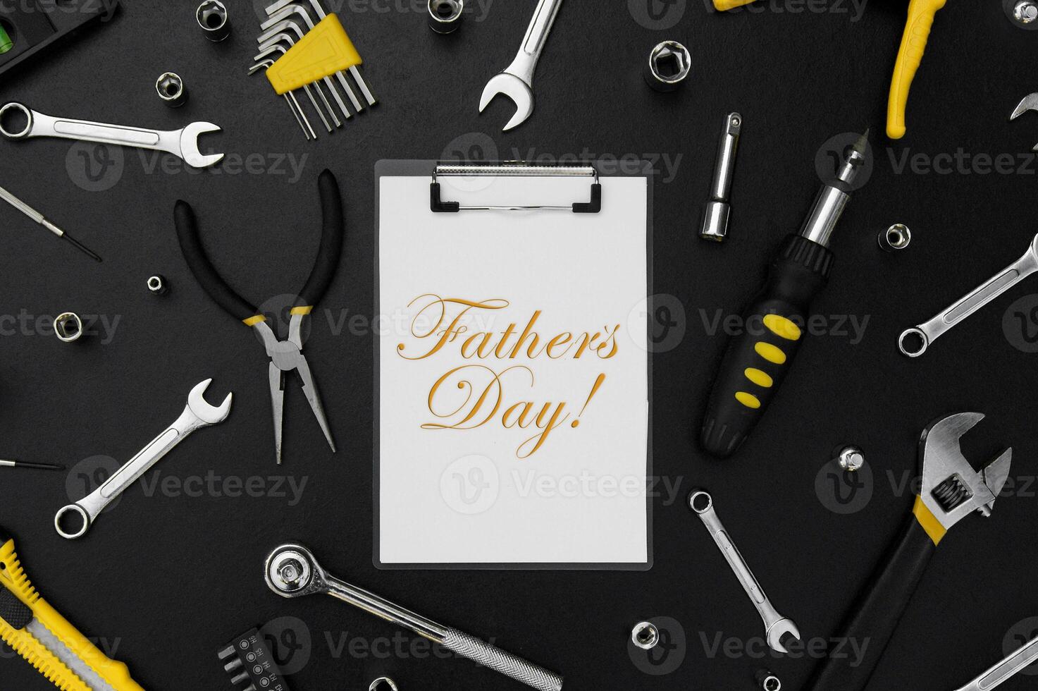 Lettering Happy Father's Day with many different tools for repair work on a black table. photo