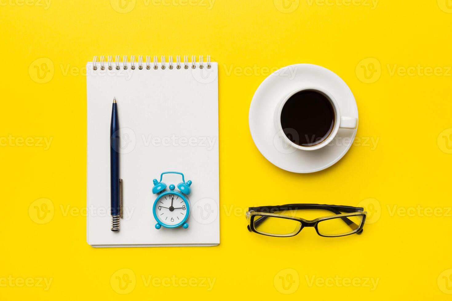 Modern office desk table with notebook and other supplies with cup of coffee. Blank notebook page for you design. Top view, flat lay photo