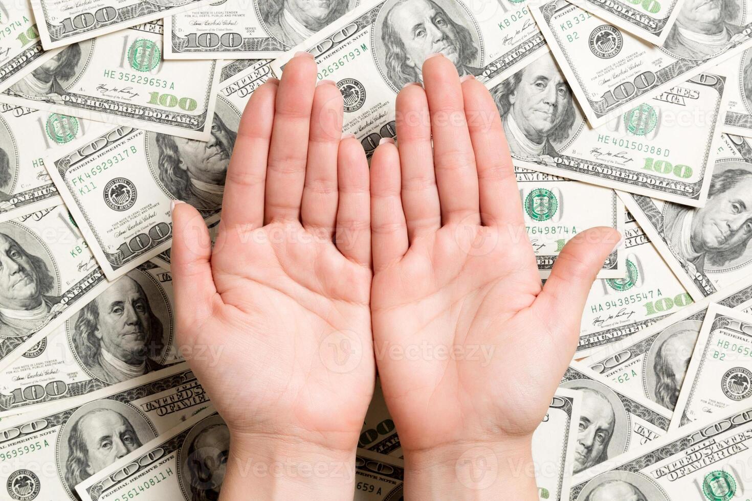 Top view of female hands on dollar background. Wealth concept with empty space for your design. Begging money concept photo