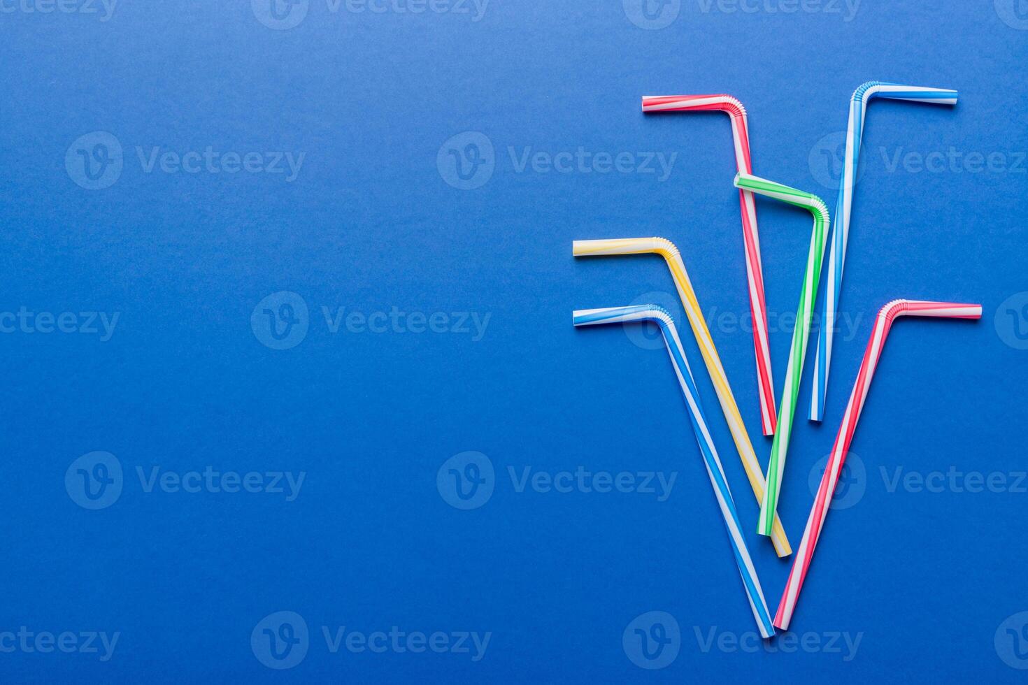 Drinking straws for party on Colored background. Top view of colorful plastic disposable straws for summer cocktails. different straws for juice with copy space photo