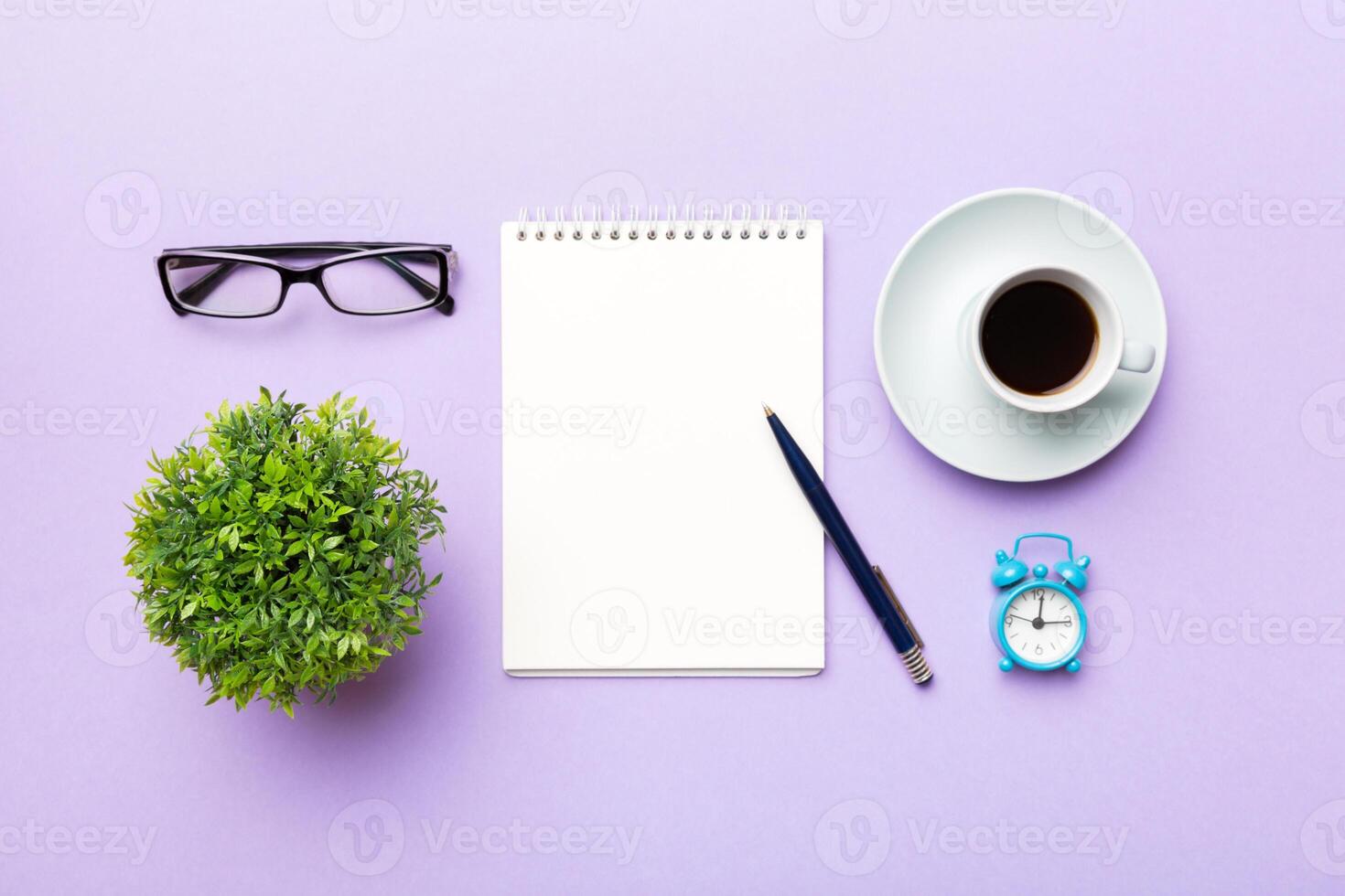 Modern office desk table with notebook and other supplies with cup of coffee. Blank notebook page for you design. Top view, flat lay photo