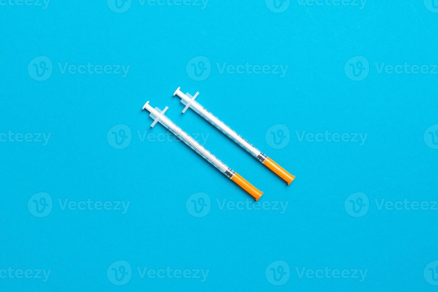 Top view of two insulin syringe at colorful background with copy space. High level of glucose concept photo