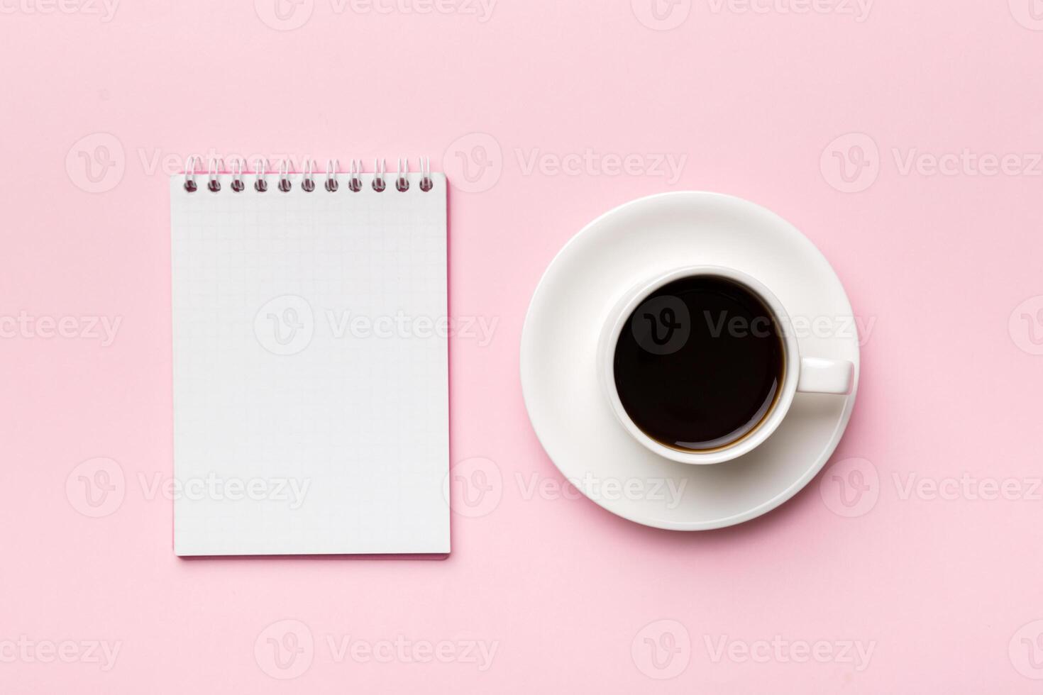 Modern office desk table with notebook and other supplies with cup of coffee. Blank notebook page for you design. Top view, flat lay photo