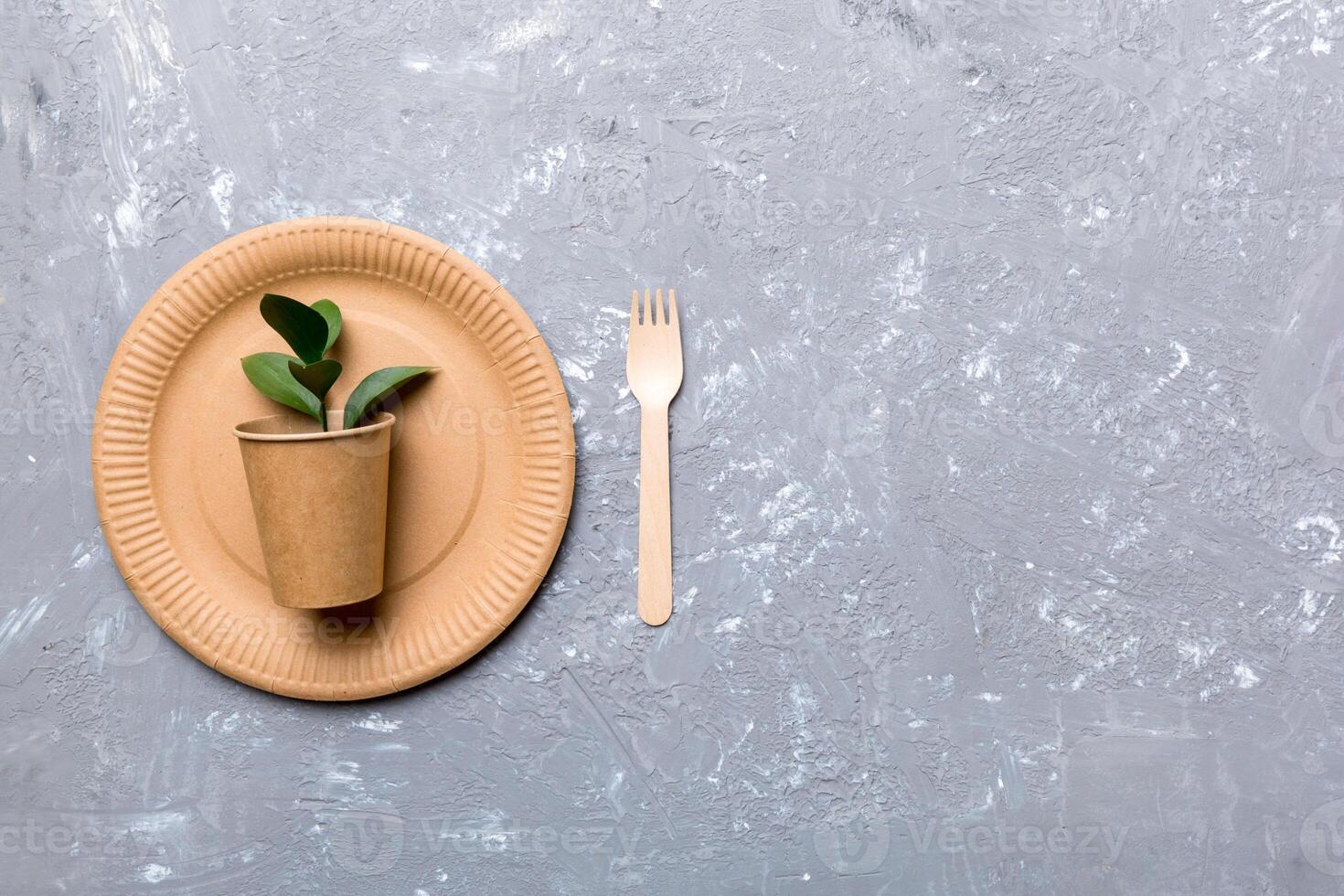 set of empty reusable disposable eco-friendly plates, cups, utensils on light white colored table background. top view. Biodegradable craft dishes. Recycling concept. Close-up photo