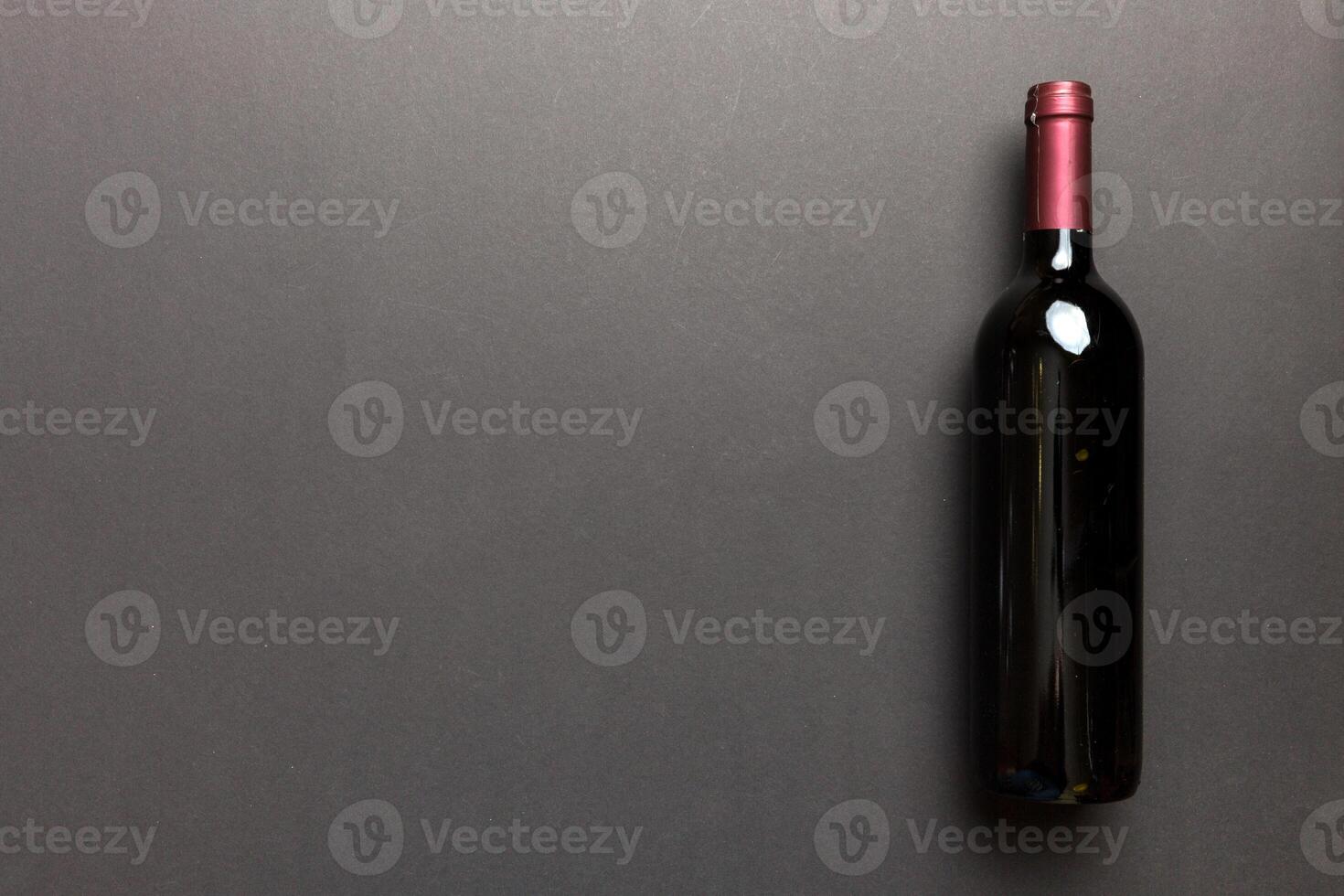 One Bottle of red wine on colored table. Flat lay, top view wth copy space photo