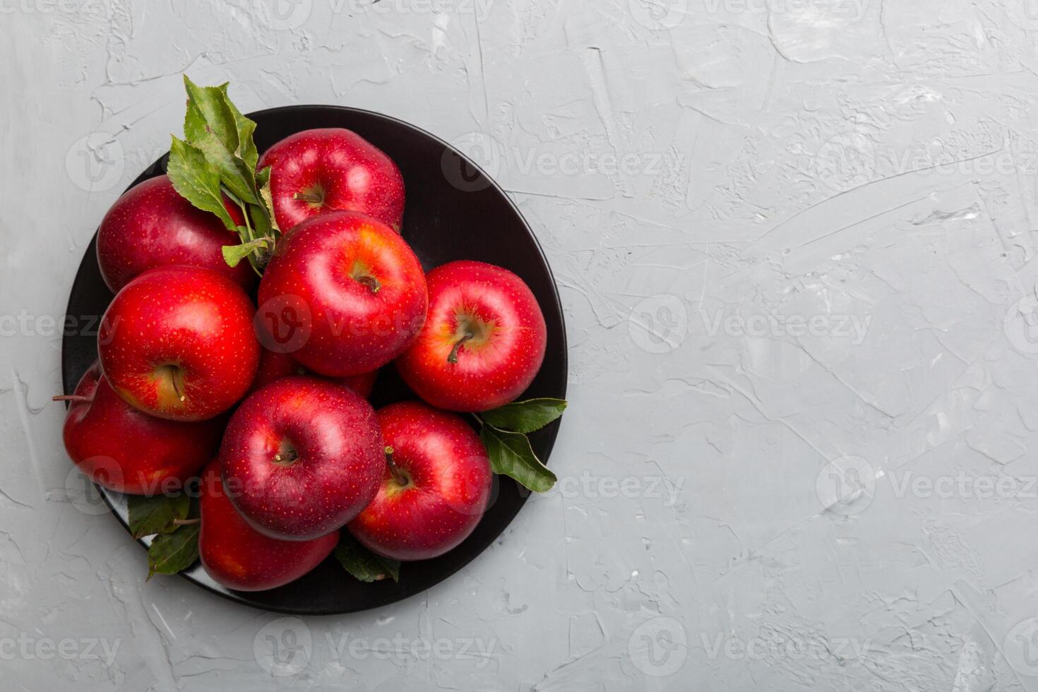 Many red apples on cement background, top view. Autumn pattern with fresh apple above view photo