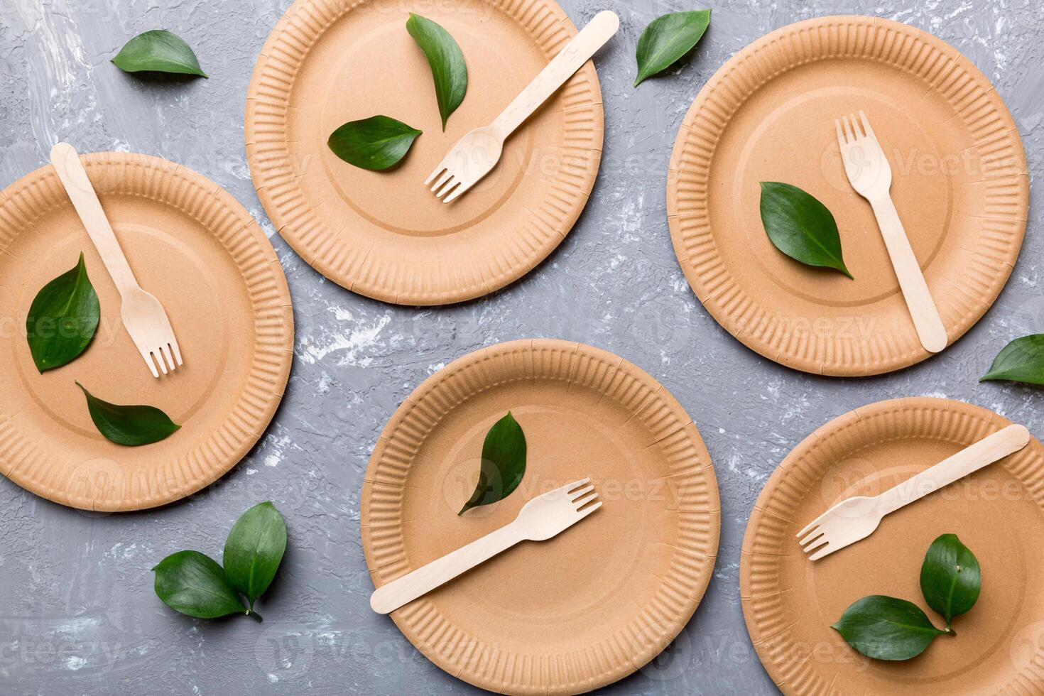 set of empty reusable disposable eco-friendly plates, cups, utensils on light white colored table background. top view. Biodegradable craft dishes. Recycling concept. Close-up photo