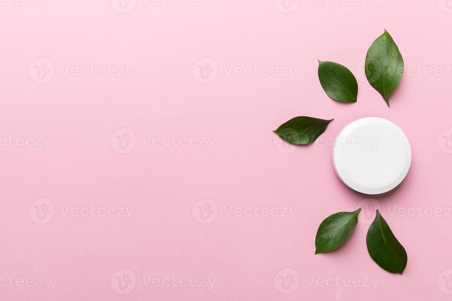 Organic cosmetic product with green leaves on color background. Copy space, flat lay photo
