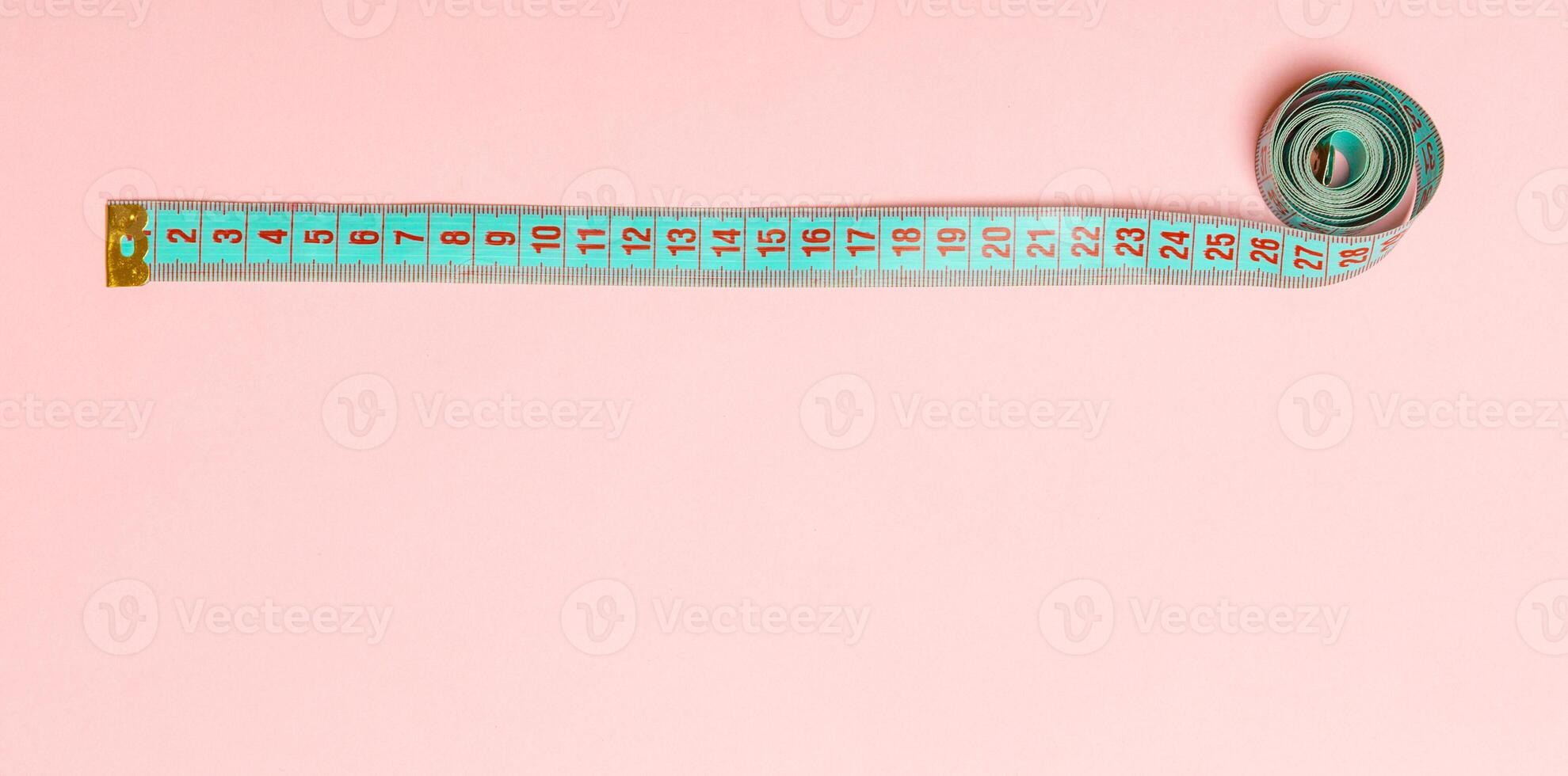 Top view of measure tape in the form of frame on pink background. Balanced eating concept with copy space photo