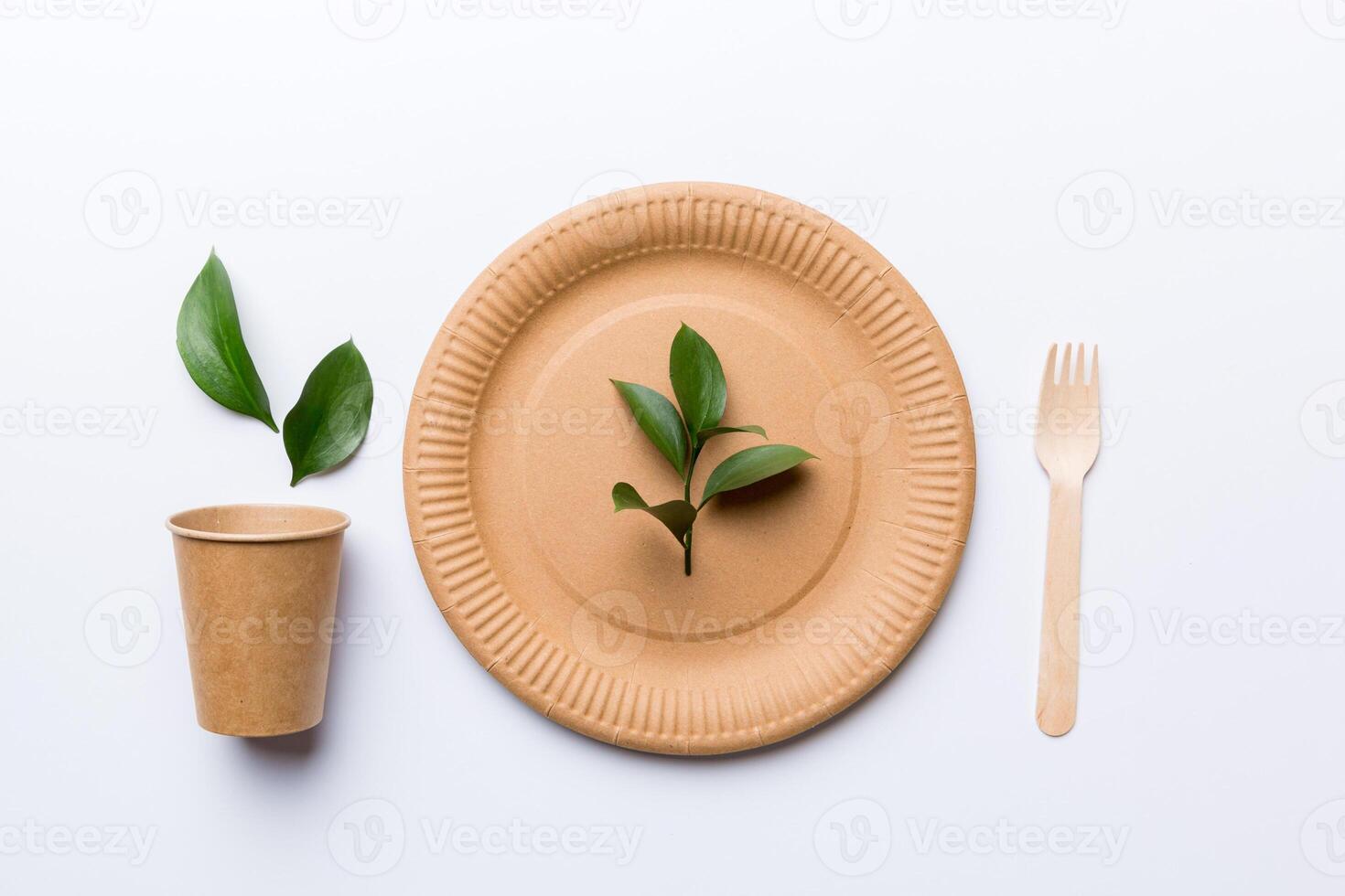 set of empty reusable disposable eco-friendly plates, cups, utensils on light white colored table background. top view. Biodegradable craft dishes. Recycling concept. Close-up photo