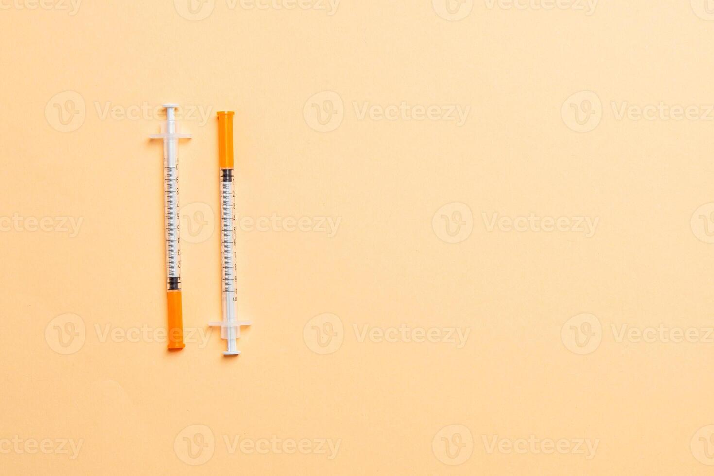 Top view of two insulin syringe at colorful background with copy space. High level of glucose concept photo