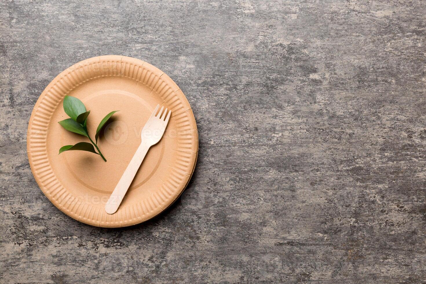 set of empty reusable disposable eco-friendly plates, cups, utensils on light white colored table background. top view. Biodegradable craft dishes. Recycling concept. Close-up photo