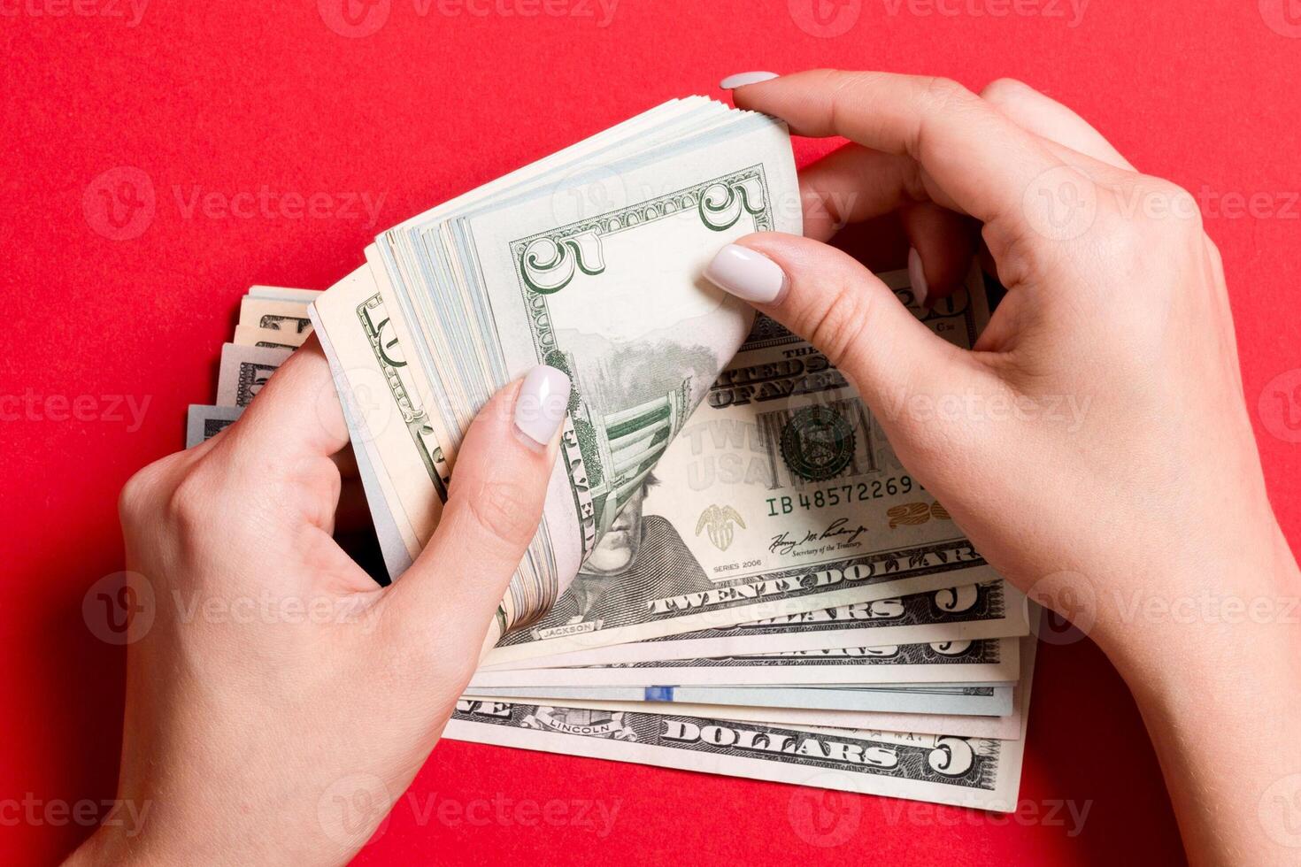 Top view of female hands counting money. Five and other dollar banknotes on colorful background. Business concept photo