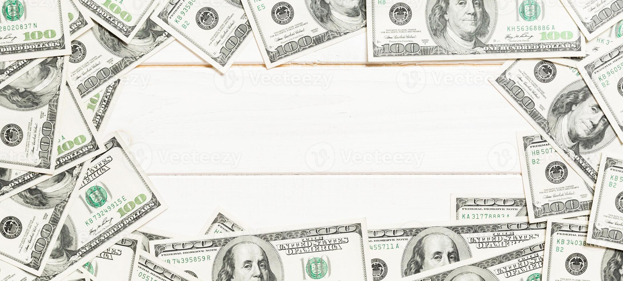 Frame of one hundred dollar bills with empty space for your design. Top view of business concept on white wooden background with copy space photo