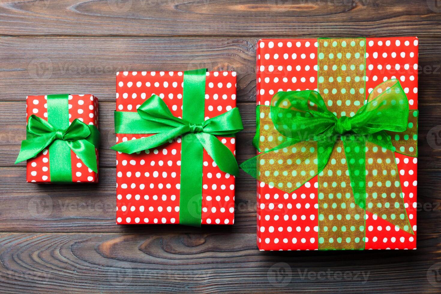 Beautiful gift box with a colored bow on the dark wooden table. Top view with copy space for you design. Christmas concept photo
