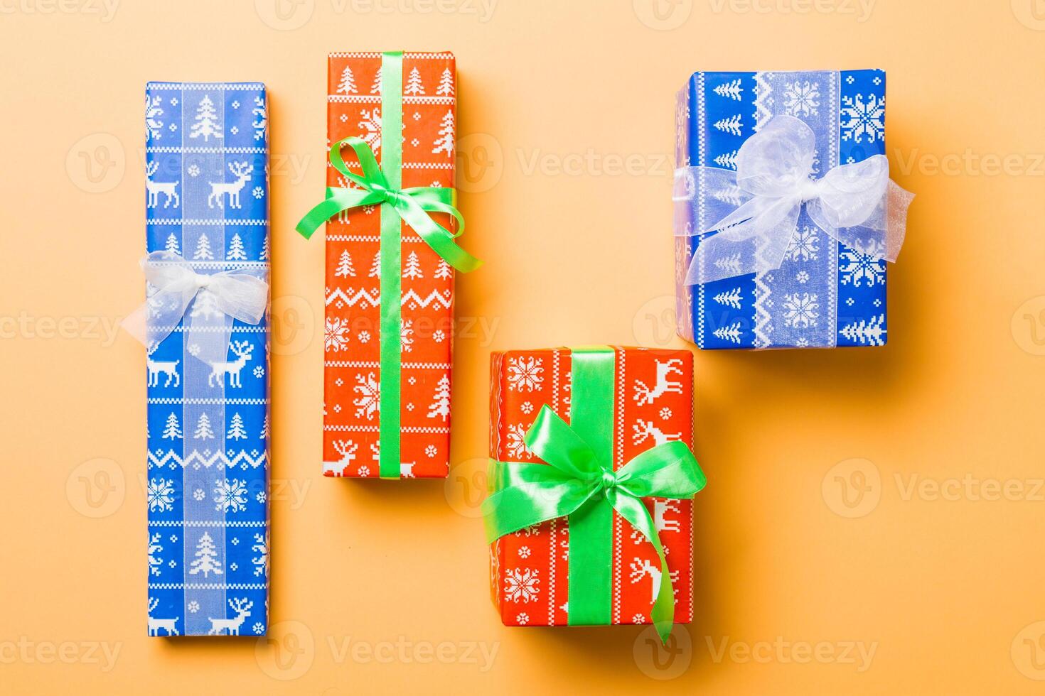 Top view Christmas present box with white and green bow on orange background photo