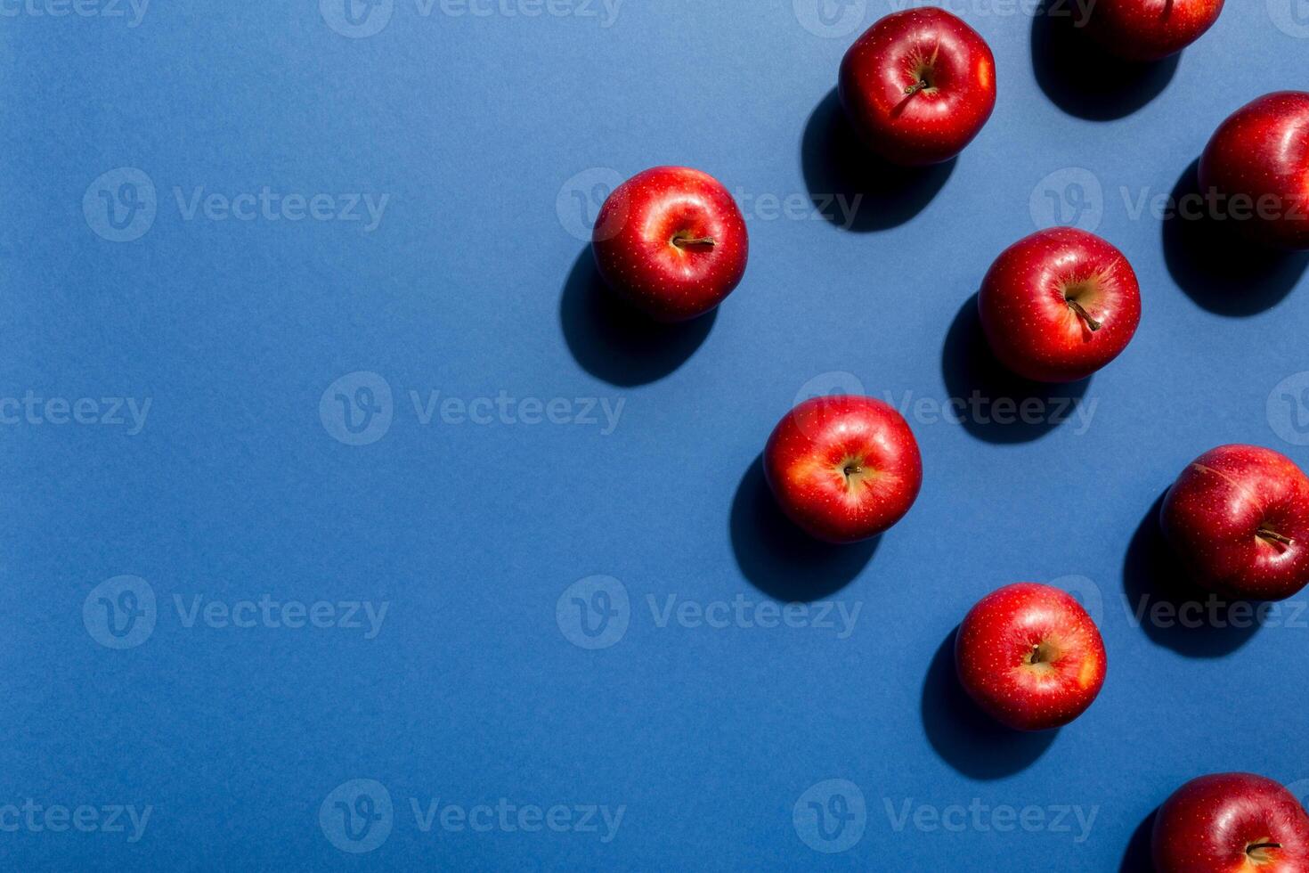 Many red apples on colored background, top view. Autumn pattern with fresh apple above view with copy space for design or text photo