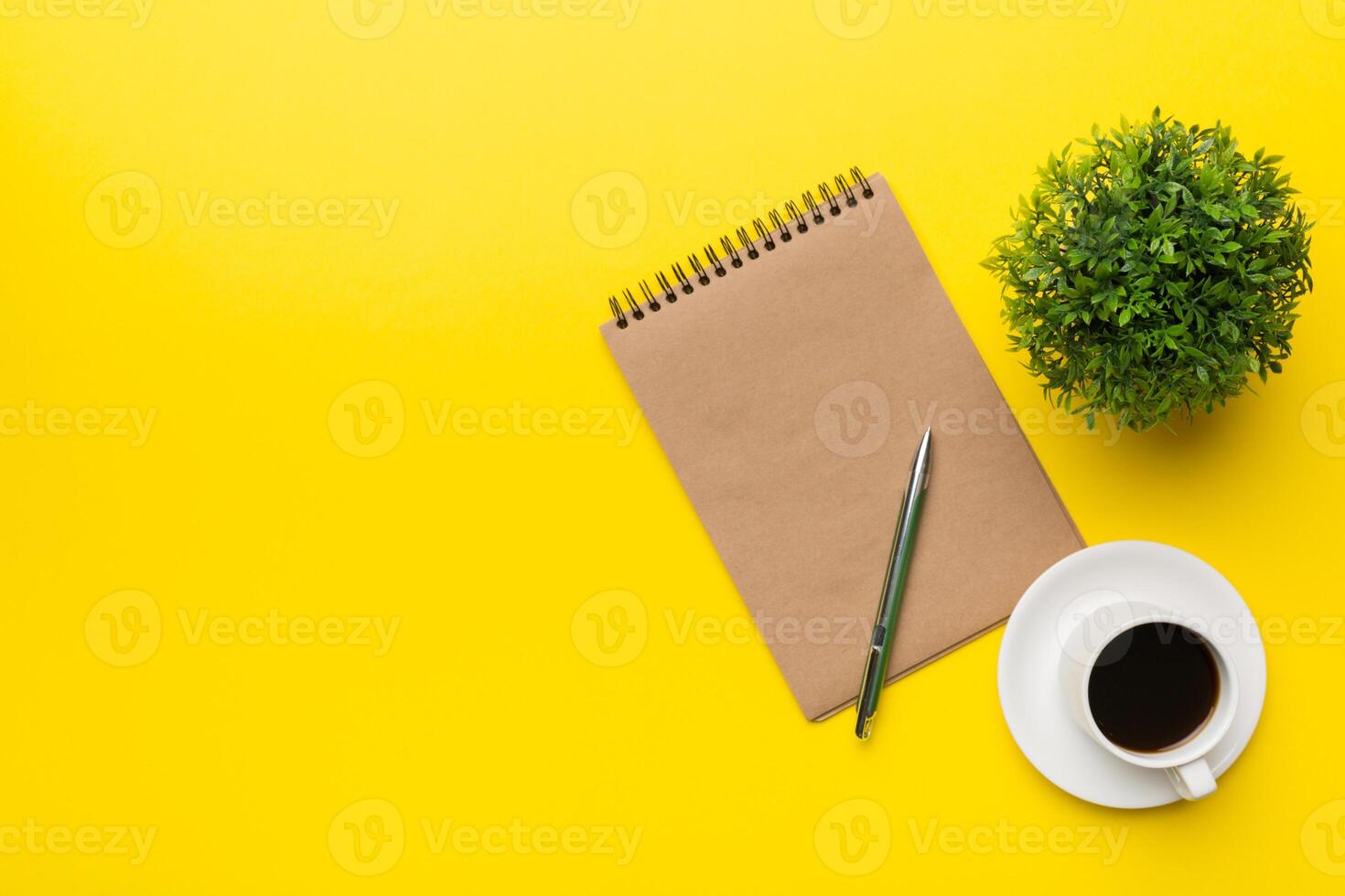 Modern office desk table with notebook and other supplies with cup of coffee. Blank notebook page for you design. Top view, flat lay photo