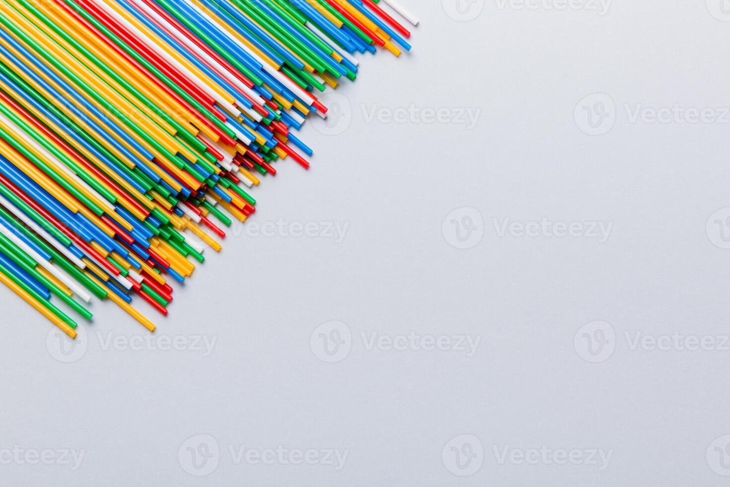 Heap of colorful plastic drinking straws on Colored background, flat lay. Copy Space for text photo